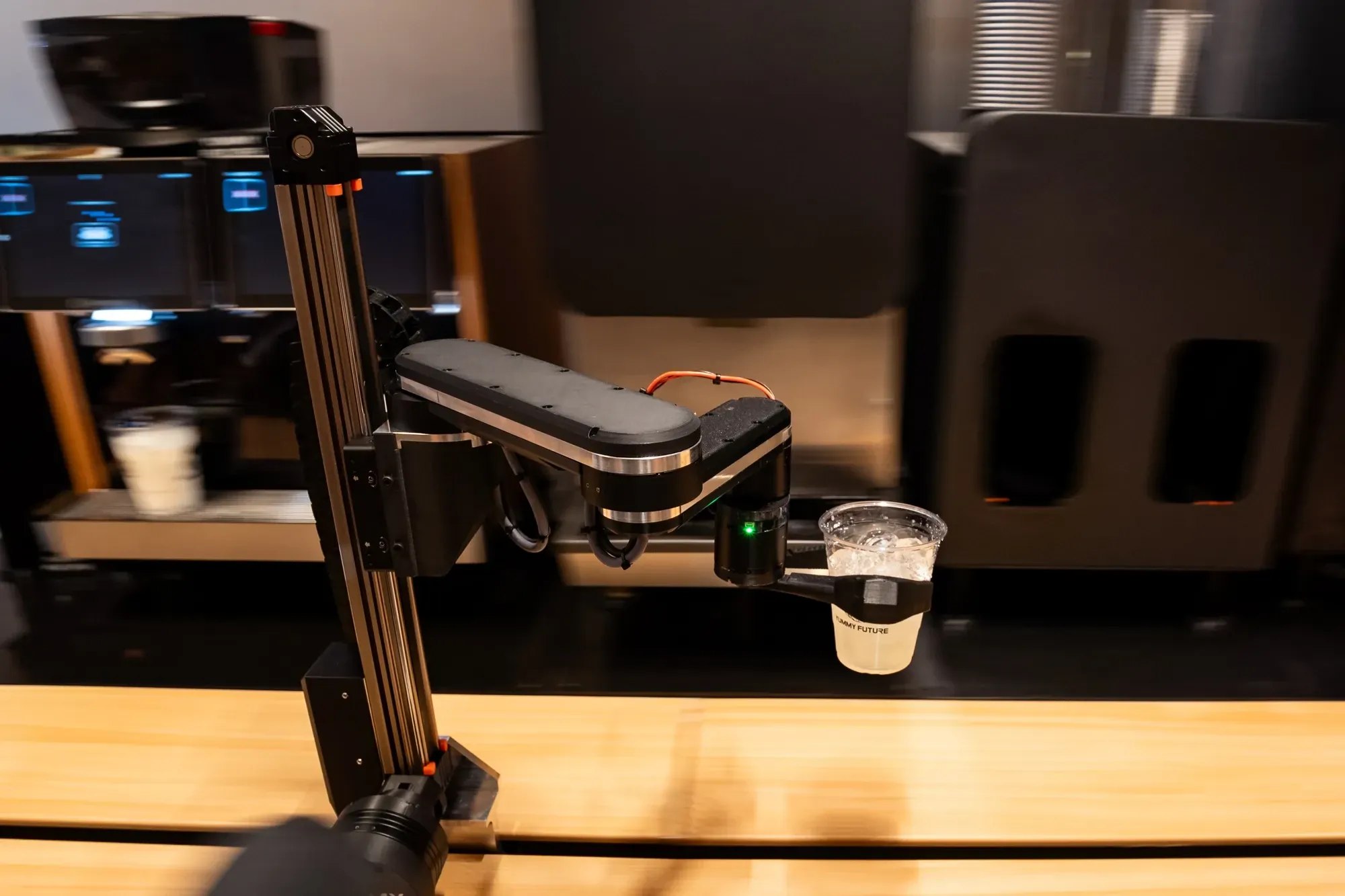The robotic arm at our shop handing over a finished iced drink