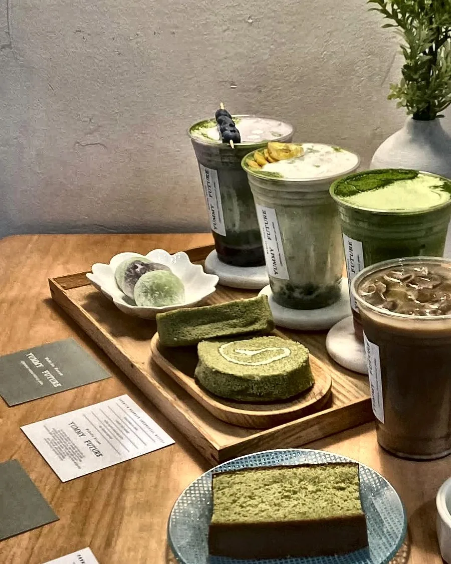 Matcha drinks, roll cake and mochi on a wood tray