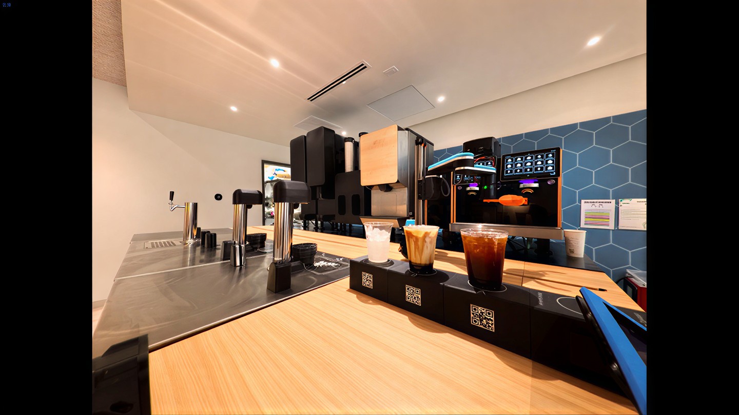 The robotic arm mid-pour behind the bar, three drinks queued and QR-coded