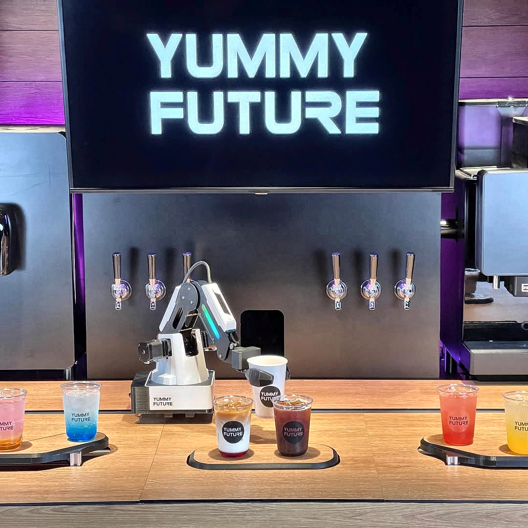 Yummy Future robotic arm pouring a drink behind the counter