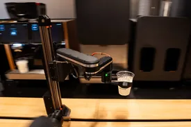 The robot arm lifting an iced drink at the bar